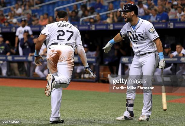 Carlos Gomez of the Tampa Bay Rays is congratulated after scoring by Kevin Kiermaier in the third inning during a game against the Detroit Tigers at...