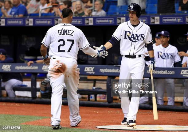 Carlos Gomez of the Tampa Bay Rays is congratulated after scoring by Daniel Robertson in the third inning during a game against the Detroit Tigers at...