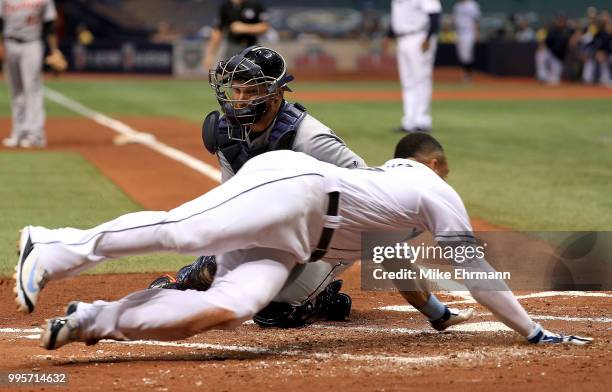 Carlos Gomez of the Tampa Bay Rays scores in front of the tag by John Hicks of the Detroit Tigers during a game at Tropicana Field on July 10, 2018...