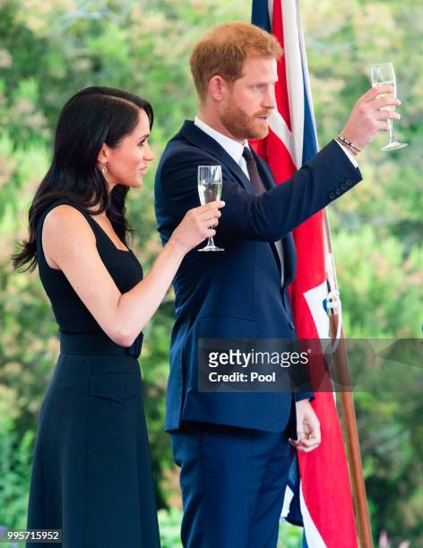 Prince Harry, Duke of Sussex and Meghan, Duchess of Sussex raise a toast as they attend a Summer Party at the British Ambassador's residence at...