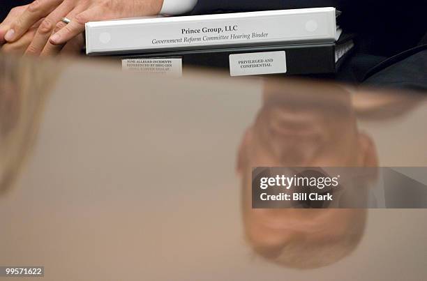 Erik Prince, chairman of the Prince Group, LLC and Blackwater USA, is seen reflected in the witness table holding notebooks as he waits to testify...