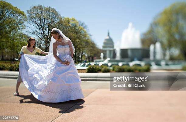 From left, Amanda Dale, of Dallas, helps arrange the wedding dress train before taking photos of her sister Elisa Harvey, of Falls Church, Va., in...