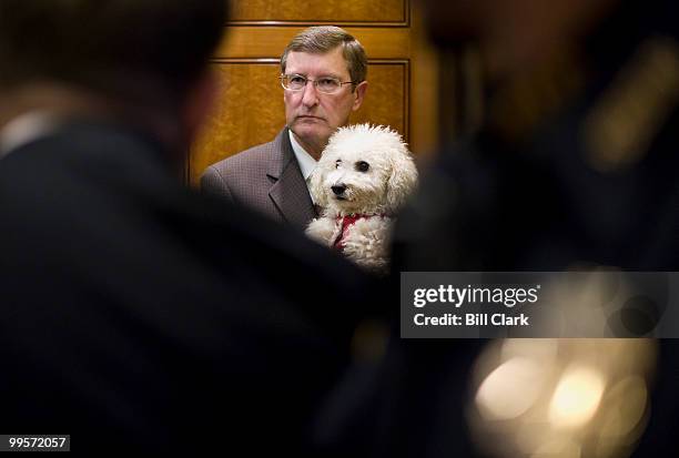 Sen. Kent Conrad, D-N. Dak., and his dog Dakota, wait for the elevator doors to close as reporters ask questions following a vote on the Senate Floor...