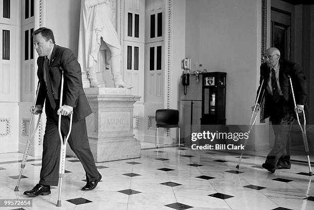 Rep. Steve Kagen, D-Wisc., left, followed closely by Reb. John Dingell, D-Mich., make their way through the Will Rogers Corridor on crutches...