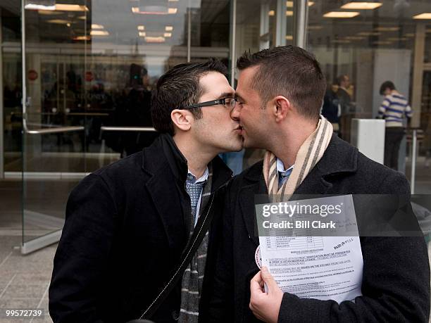 Jonathan Howard, left, and Gregory Jones, both of DC, kiss in front of the Moultrie courthouseafter applying for their marriage license in DC Suprior...