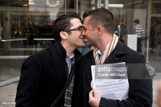 Jonathan Howard, left, and Gregory Jones, both of DC, kiss in front of the Moultrie courthouseafter applying for their marriage license in DC Suprior...
