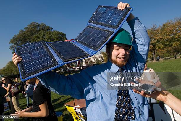 Paul Plumlee, of Knoxville, Tenn., with the Energy Action Coalition, shows off his solar cell phone charger during the Youth Rally for Clean Energy...