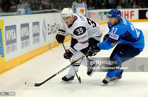 Mike Lundin of United States battles for the puck with Evgeni Bumagin of Kazakhstan during the IIHF World Championship final round match between USA...