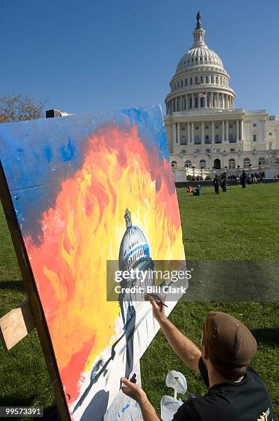 Michael Mayosky, from the University of Illinois, paints the Capitol dome with flames rising up in the background during the Youth Rally for Clean...