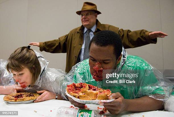 George Washington University students Sara Gimmy and O.G. Oyiborhoro compete in a cherry pie eating contest as university president Stephen...