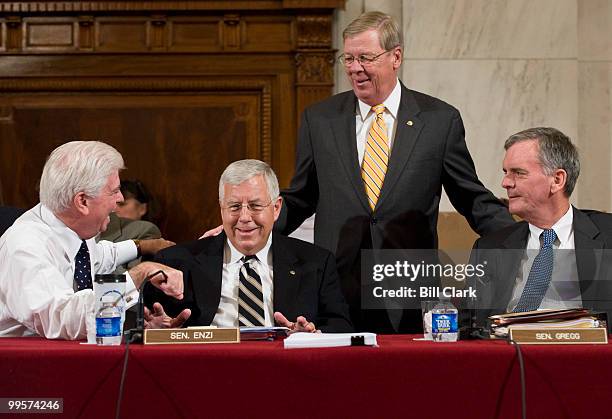 From left, chairman Chris Dodd, D-Conn., holds his hand over the microphone as he speaks with Sen. Michael Enzi, R-Wyo., Sen. Johnny Isakson, R-Ga.,...