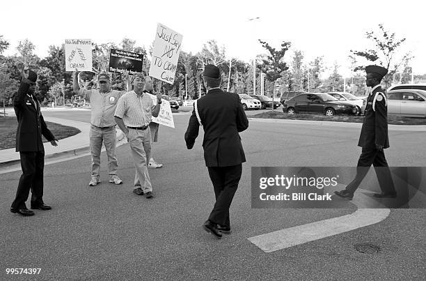 North Point High School JROTC members stop three men holding signs as they walk towards the start of the line waiting for House Majority Leader Steny...