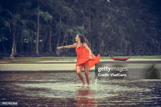 woman dancing on the beach - woman long dress beach stock pictures, royalty-free photos & images