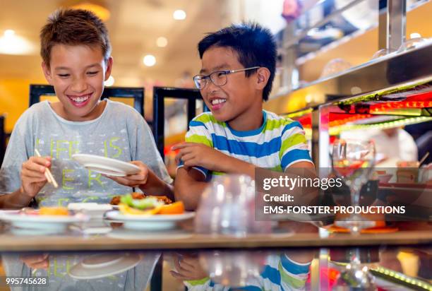 two brothers of different fathers in asian restaurant - ems stockfoto's en -beelden