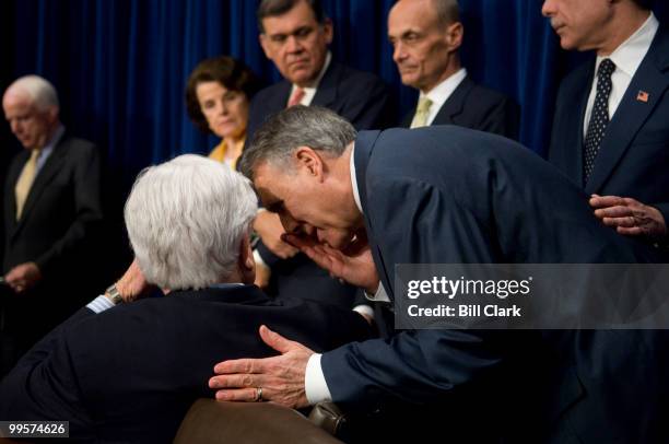 Sen. Jon Kyl, R-Ariz., whispers to Sen. Ted Kennedy, D-Mass., during the news conference announcing that bipartisan group of Senate negotiators had...