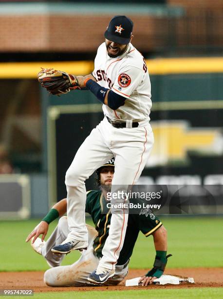 Marwin Gonzalez of the Houston Astros reacts after he was spiked on his glove hand by Dustin Fowler of the Oakland Athletics in the first inning at...