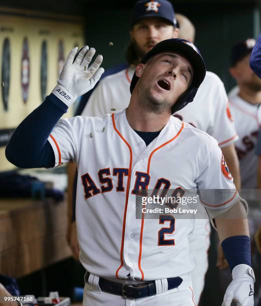 Alex Bregman of the Houston Astros celebrates in the dugout after hitting a home run in the first inning against the Oakland Athletics at Minute Maid...