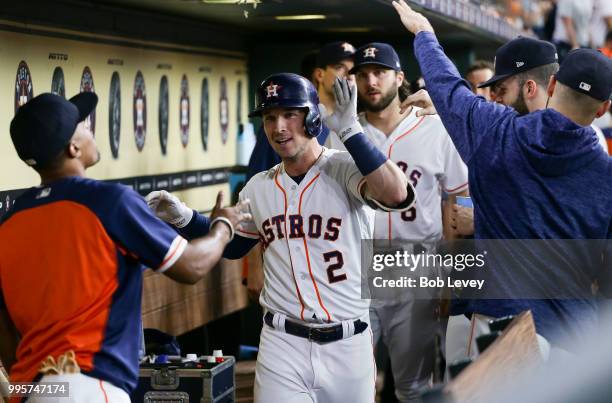 Alex Bregman of the Houston Astros celebrates in the dugout after hitting a home run in the first inning against the Oakland Athletics at Minute Maid...