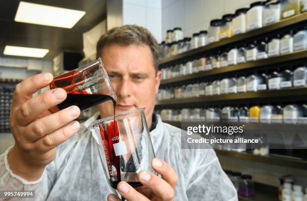 Lab manager Jochen Gottfriedsen fills "Supreme Blood External" fake blood into a measuring beaker at the Kryolan company lab in Berlin, Germany, 21...