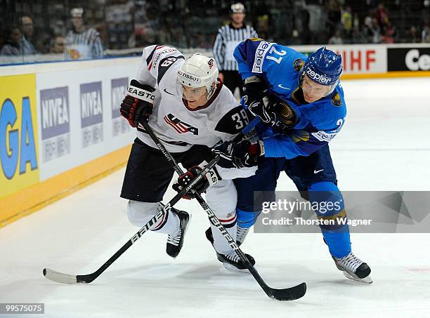 Mike Lundin of United States battles for the puck with Evgeni Bumagin of Kazakhstan during the IIHF World Championship final round match between USA...