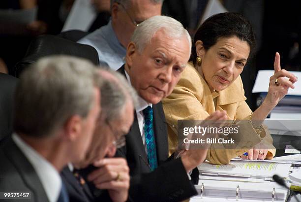 From right, Sen. Olympia Snowe, R-Maine, and Sen. Orrin Hatch, R-Utah, try to get the attention of chairman Max Baucus, left, during the Senate...