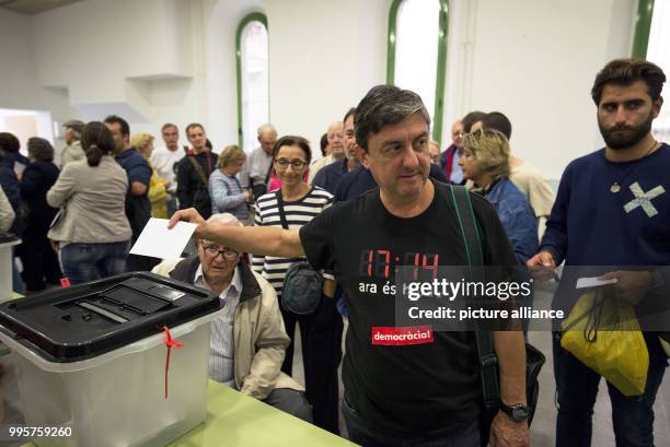 Man with a pro-Catalan independence T-shirt casts his ballot during the Catalan independence referendum at Escola de Treball school in Barcelona,...