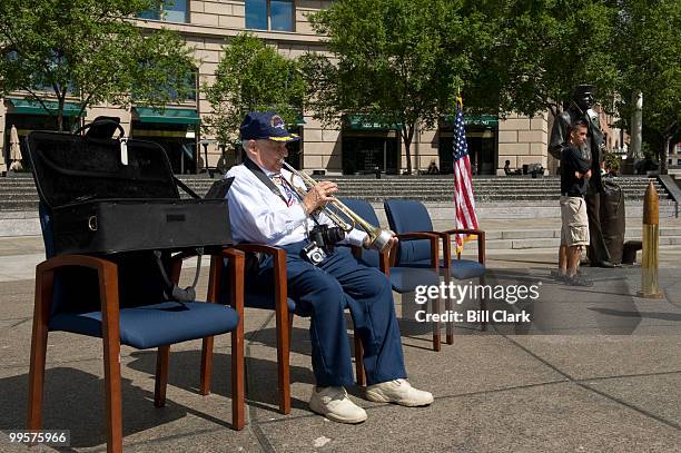 Buddy Verdi, who served in World War II aboard the USS Springfield, warms up with his trumpet for his playing of taps during the memorial service in...