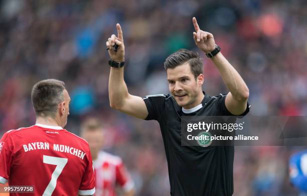 Referee Harm Osmers calls for the video to be checked after an incident in the penalty area involving Berlin's Darida as Bayern's Franck Ribery...