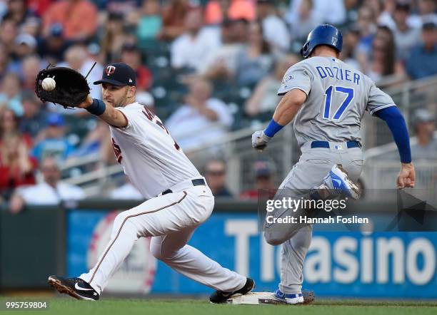 Hunter Dozier of the Kansas City Royals is safe at first base as Joe Mauer of the Minnesota Twins fields the ball during the second inning of the...