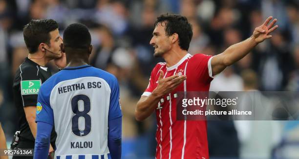 Bayern's Mats Hummels in discussion with Harm Osmers while Hertha's Salomon Kalou listens during the German Bundesliga football match between Hertha...