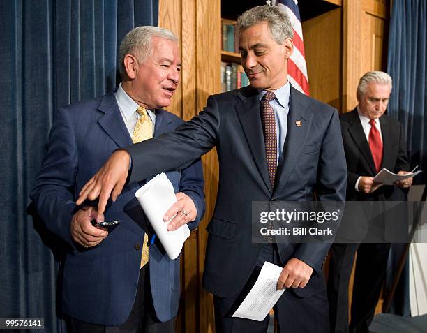 Rep. Nick Rahall, D- W.Va., tries to silence the speaker phone feature on his Blackberry as Rep. Rahm Emanuel, D-Ill., watches during the Democrats'...