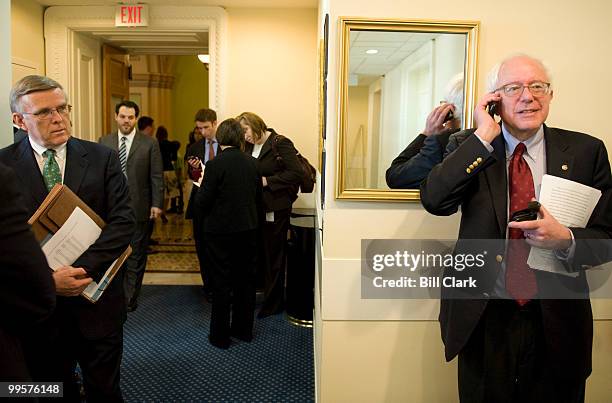 From left, Sen. Byron Dorgan, D-N. Dak., looks on as Sen. Bernie Sanders, I-Vt., talks on his cell phone before the start of their news conference in...