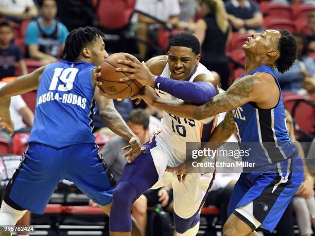Shaquille Harrison of the Phoenix Suns drives between Braian Angola-Rodas and Jay Wright of the Orlando Magic during the 2018 NBA Summer League at...
