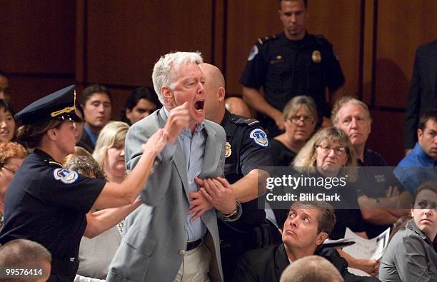 Protester is removed form the hearing room after shouting anti-war statements as Armed Forces Commander in Iraq Gen. David Petraeus and U.S....