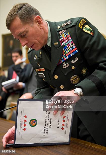 Gen. David Petraeus, commander of the U.S. Central Command, gathers his papers during a break in the House Armed Services Committee hearing on the...