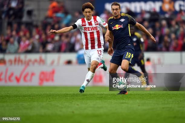 Cologne's Yuya Osako and the Leipzig player Stefan Ilsanker during the German Bundesliga match between 1. FC Cologne and RB Leipzig at the...