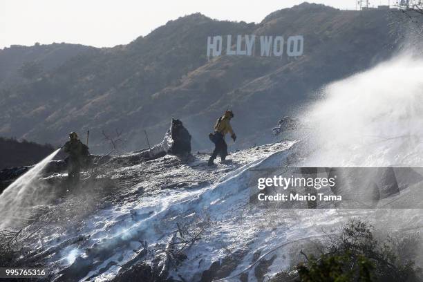 Firefighters battle the Griffith fire at Griffith Park, with the Hollywood sign in the background, on July 10, 2018 in Los Angeles, California....