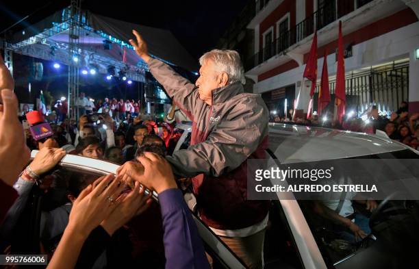 Mexico's then presidential candidate for the MORENA party, Andres Manuel Lopez Obrador , waves to supporters from his car after a campaign rally in...