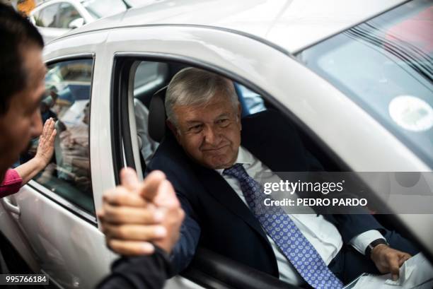 Mexico's President-elect Andres Manuel Lopez Obrador shakes hands with a supporter as leaves the party's headquarters in Mexico City on July 9, 2018....
