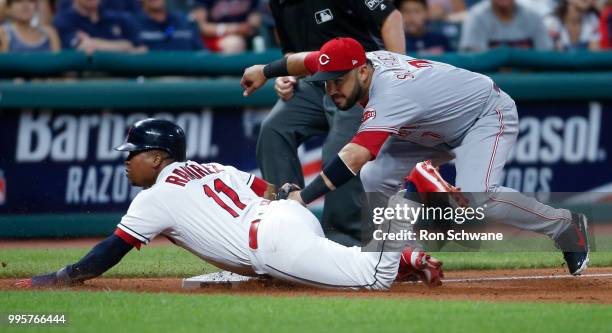 Jose Ramirez of the Cleveland Indians slides safely into third base as Eugenio Suarez of the Cincinnati Reds attempts a tag during the eighth inning...