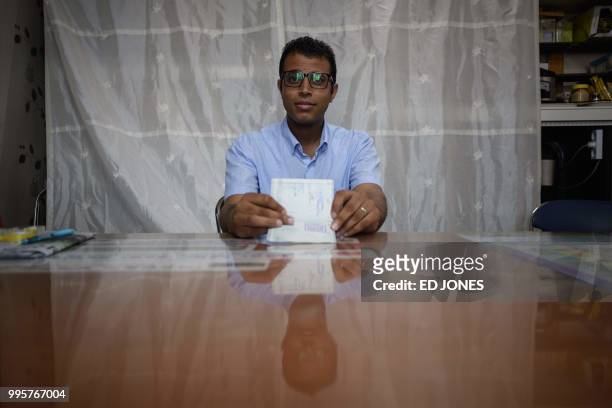 In a photo taken on July 4 Yemeni asylum seeker Mohammed Salem Duhaish shows his South Korean visa while sitting in a room at the office of Jeju NGO...