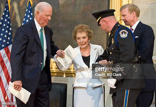 Former First Lady Nancy Reagan is helped to the podium by former Treasury Secretary James Baker, left, and Frederick Ryan, chairman of the Board of...