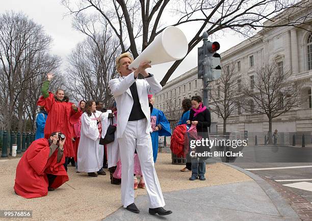 Reverend Billy and the Stop Shopping Gospel Choir cross Constitution Avenue by the Russell Senate Office Building on their way to the Rayburn House...