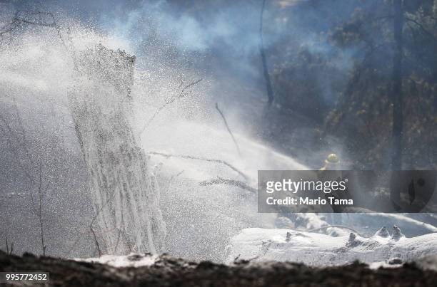 Firefighter sprays foam on the Griffith fire at Griffith Park on July 10, 2018 in Los Angeles, California. Tourists had to be evacuated from the...