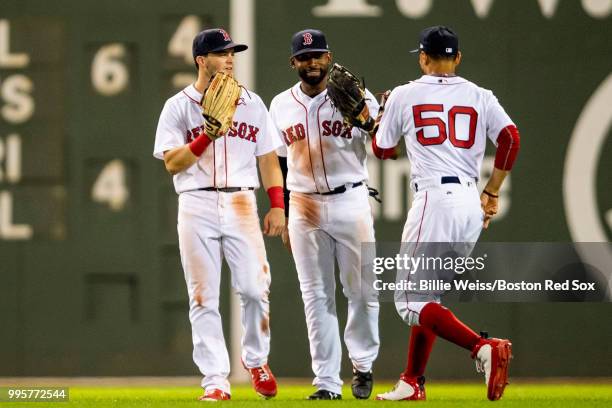 Andrew Benintendi, Jackie Bradley Jr. #19, and Mookie Betts react after recording the final out of a game against the Texas Rangers on July 10, 2018...