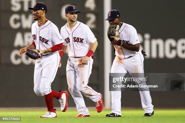 Mookie Betts, Andrew Benintendi and Jackie Bradley Jr. #19 of the Boston Red Sox celebrate after a win over the Texas Rangers at Fenway Park on July...