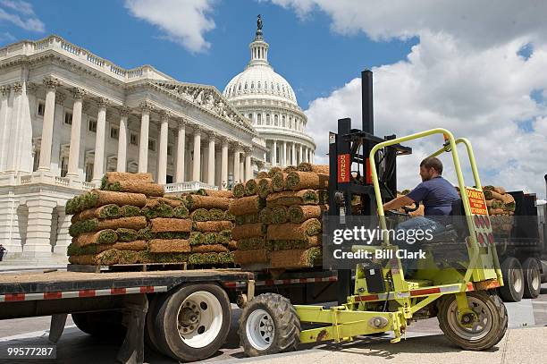 An unidentified worker unloads fresh sod bound for the grassy area on the East Front of the Capitol, which had been the construction site for the...