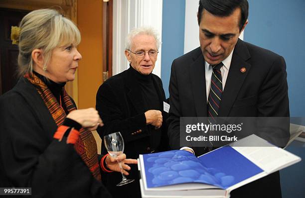 From left, author Daphne Larkin, and photographer Charles O'Rear, show off their book "Wine Across America: A Photographic Road Trip" to Rep. Darrell...