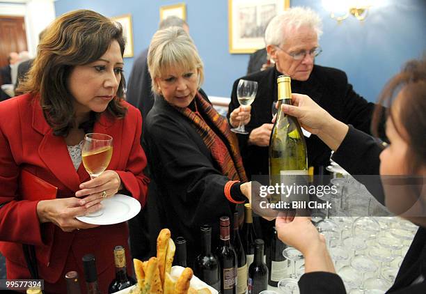 From left, Rep. Hilda Solis, D-Calif., looks at a bottle of wine with author Daphne Larkin, and photographer Charles O'Rear, who collaborated on...