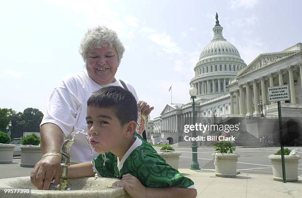 Delia Guerra helps her grandson Rene Guerra with a water fountain on the east side of the Capitol Thursday afternoon as tourists braved the hot sun...